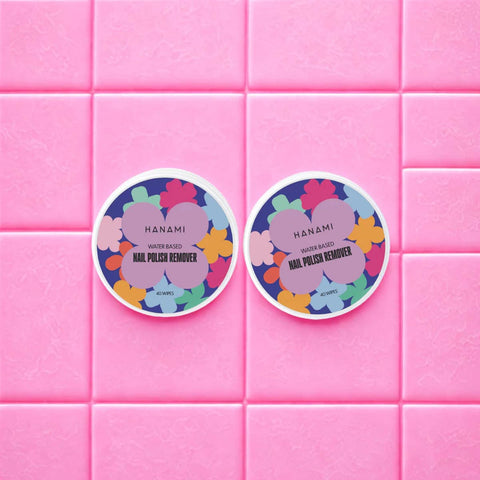 Two Hanami nail polish remover containers on a pink tiled background.