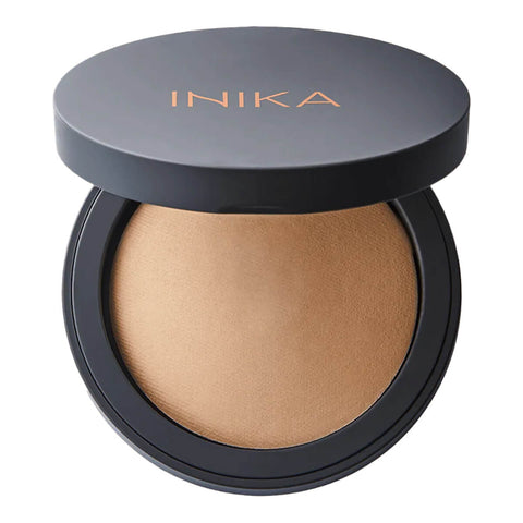 INIKA Organic Baked Mineral Foundation 8g shade Nurture per file name, open compact with a grey lid above a light tan pressed powder on white