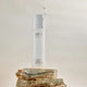 INIKA Organic Pure Biome Gentle Milk Cleanser 100ml lifestyle shot of the bottle on a stack of stones with water drops falling