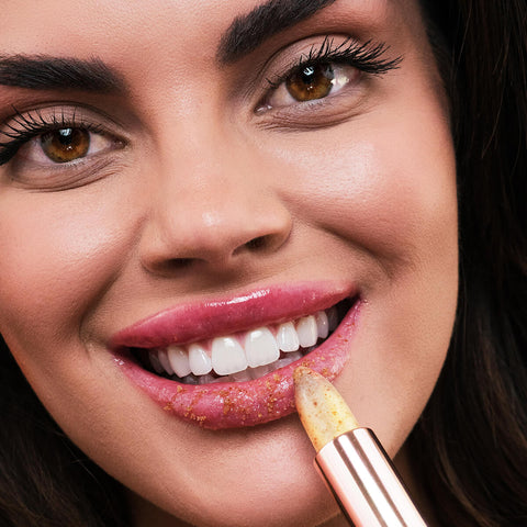 Close-up of a young woman applying the lip scrub.