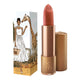 Lipstick next to box packaging that pictures a woman in a white dress next to a giraffe. Flower detail on lipstick case lid.