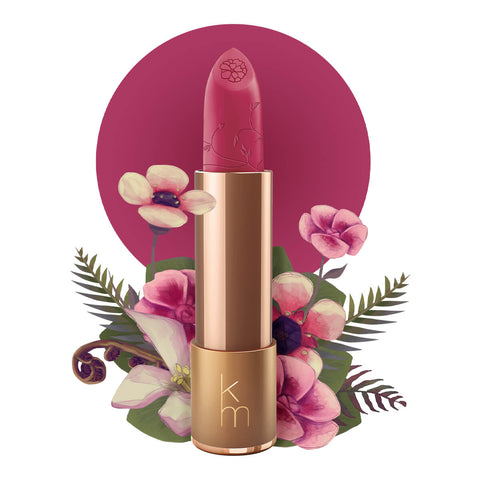 Vibrant deep pink shade, gold lipstick case against a floral background. Lipstick detailed with vines & flower on the tip. Natural, clean cosmetics.