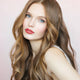 Young woman with fair skin tone & blonde hair wearing violet mousse lipstick.