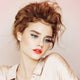 Young woman with fair, freckly skin tone & red hair wearing coral dawn lipstick.