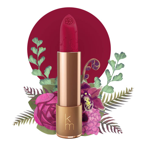 Lipstick detailed with vines & a flower on the tip, set against a floral background. 