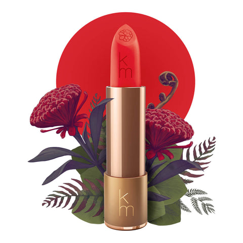 Lipstick detailed with KM initials & flower on the tip, set against a floral background. 