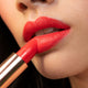 Close-up of woman applying rymba rhythm to the lips.