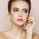 Young woman with fair skin & brunette hair wearing camellia morning lipstick.