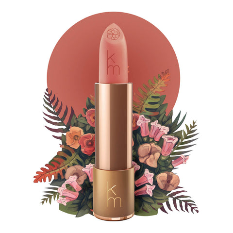 Lipstick detailed with KM initials & flower on the tip, set against a floral background. 