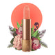 Lipstick detailed with vines & flower on the tip, set against a floral background. 