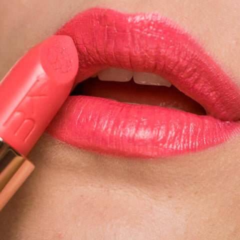 Close-up of poppy passion lipstick applied on the lips. 