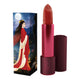 Lipstick next to box packaging that pictures a woman in a red robe dress in the moonlight. Red lipstick case with flower detail on lid. 