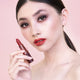 Young woman with fair skin tone & dark hair wearing fiery ruby lipstick, wearing complementary brown & bronze eye makeup. 
