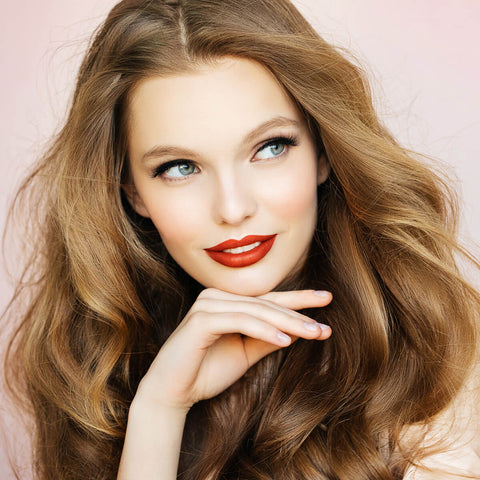 Young woman with light skin tone & dark blonde hair wearing fiery ruby lipstick.