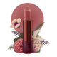 Lipstick detailed with vines & flower on the tip, set against a floral background. 