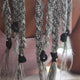 Close-up of braided hair extensions with black hair ties on a blurred background