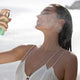 Miranda Kerr, model and owner of KORA organics spritzing Active Algae Minty Mist on her face at a beach.