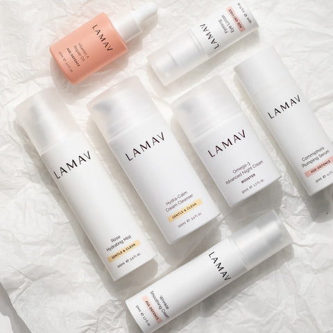 Collection of LAMAV skincare products on a textured white surface