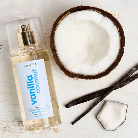 Lavanila Vanilla Coconut 150ml perfume bottle with a coconut and vanilla beans on a light wooden surface.