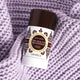 Lavanila The Healthy Deodorant Pure Vanilla lifestyle shot of the stick lying on a lilac knitted blanket, close up of the stick and the soft knit