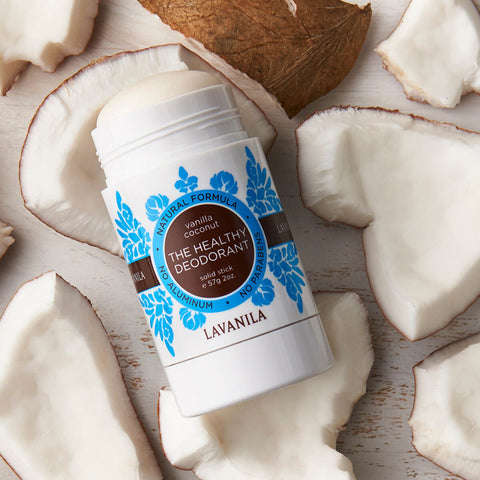 Lavanila The Healthy Deodorant Vanilla Coconut 57g lifestyle shot of the stick resting among broken pieces of white coconut, close up