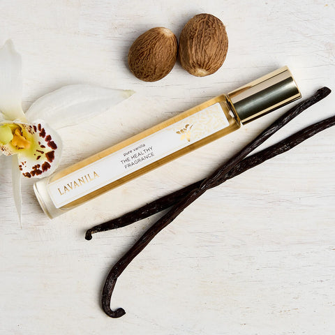 Lavanila The Healthy Fragrance Pure Vanilla 10ml lifestyle shot of the roller bottle beside whole nutmeg and vanilla pods, styled lifestyle photo