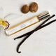 Lavanila The Healthy Fragrance Pure Vanilla 10ml lifestyle shot of the roller bottle beside whole nutmeg and vanilla pods, styled lifestyle photo