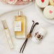 Lavanila The Healthy Fragrance Pure Vanilla 50ml lifestyle flat lay of the bottle, a roller and a deodorant stick with vanilla pods and iced cupcakes