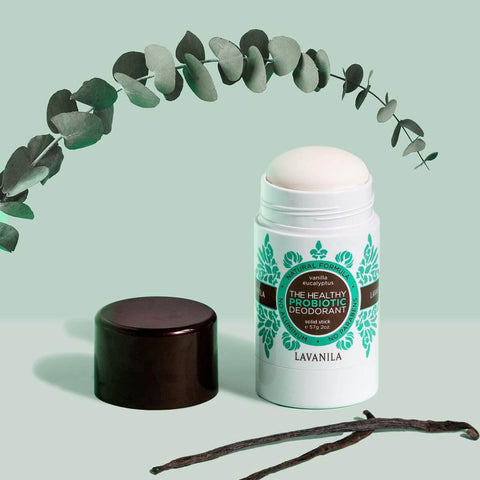 Lavanila The Healthy Probiotic Deodorant Vanilla Eucalyptus 57g lifestyle shot of the stick and cap beside vanilla pods under eucalyptus