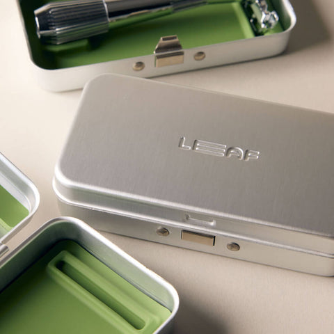 Leaf Shave Single Edge Travel Case lifestyle shot of two metal cases, one closed with the Leaf logo and one open, on a pale surface