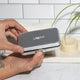 Leaf Shave Single Edge Travel Case lifestyle shot of two hands holding the closed metal case above a bathroom counter, styled lifestyle photo