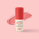 Little Urchin Red Natural Zinc Stick SPF 50+ sunscreen stick with a coral red cap and white label, set against a matching coral pink background with a textured product swatch behind it.