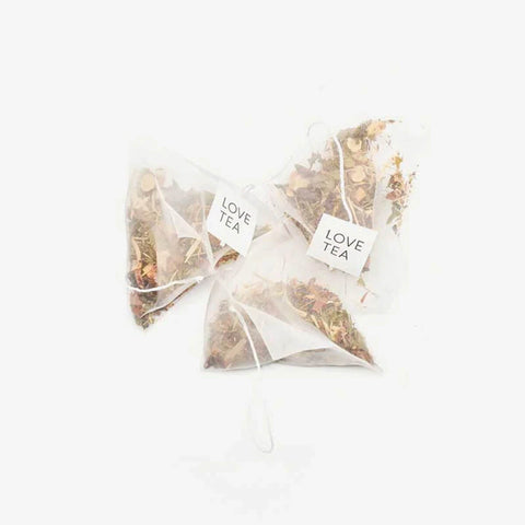 Love Tea Vitality Pyramid Tea Bags, three pyramid tea bags with Love Tea tags on a plain white background, clear product photo
