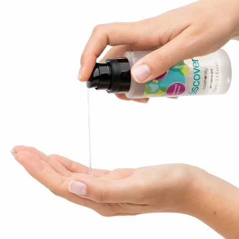 Person holding a bottle labeled 'Discover' with a pump, pouring liquid into another hand on a white background. 