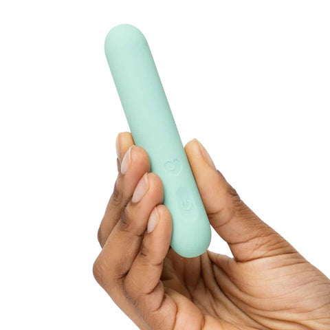 Hand holding a mint bullet vibrator against a white background.