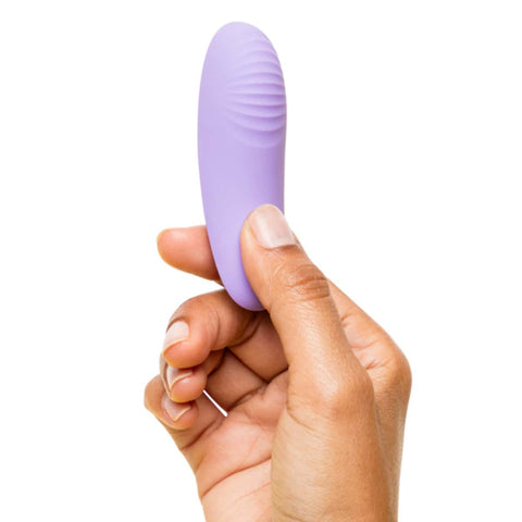 Hand holding the panty vibrator with ribbed texture on the back.