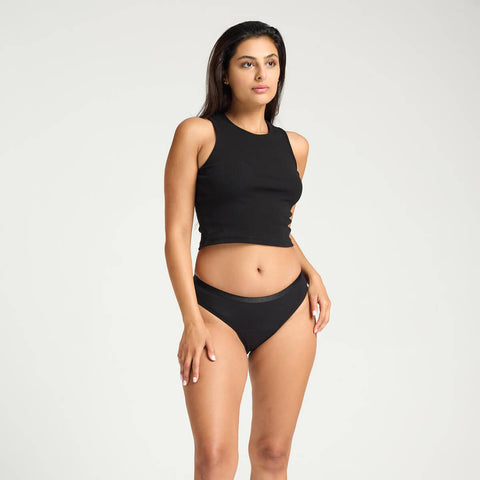 Model wearing Modibodi Classic Bikini Light-Moderate in black, front view of period underwear.