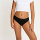 Model wearing Modibodi Teen Hipster Bikini Moderate-Heavy in black, front view of period underwear.