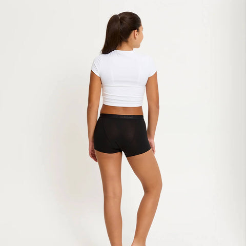 Model wearing Modibodi Teen Hipster Boyshort Moderate-Heavy in black, back view of period underwear.
