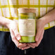 Mojo Candle Co. Wine Bottle Soy Wax Candle Cedar & Saffron lifestyle shot of two hands holding the corked bottle candle in front of a checked shirt