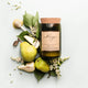 Mojo Candle Co. Reclaimed Wine Bottle Soy Wax Candle French Pear lifestyle shot of the corked bottle candle among fresh pears and white flowers