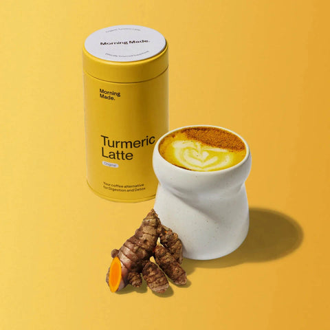 Morning Made Turmeric Latte Original Blend 300g lifestyle shot of the yellow tin beside a mug of golden latte and turmeric roots