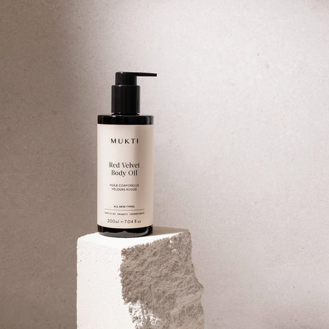 200ml pump bottle Mukti Red Velvet Body Oil placed on a stone, certified organic and suitable for all skin types.