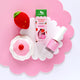 Nail polish styled on a pink and white cloud cut out with a crochet strawberry and toy cupcake.