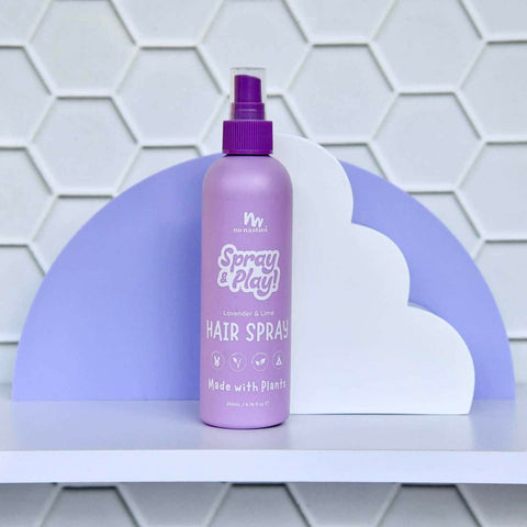 Purple 200ml spray bottle of No Nasties Slick Kids Alcohol Free Hair Spray, against a white cloud structure and purple background elements. 