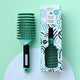 No Nasties Slick Kids Detangler Brush in Aqua colour next to its box, with a curved, solid head that has flexibility to untangle knots.