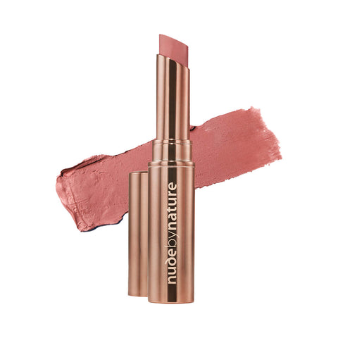Nude By Nature Creamy Matte Lipstick 01 Blush Nude 2.75g, a rose gold tube beside a swatch of dusty rose lipstick on white, clear product photo