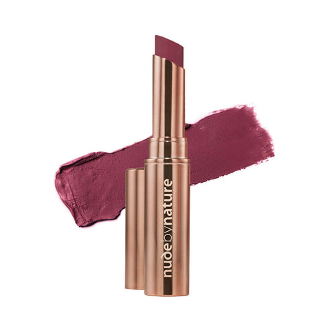 Nude By Nature Creamy Matte Lipstick Riberry, a rose gold tube beside a swatch of deep plum lipstick on white, clear product photo