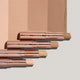 Stick concealers against a background of swatches.