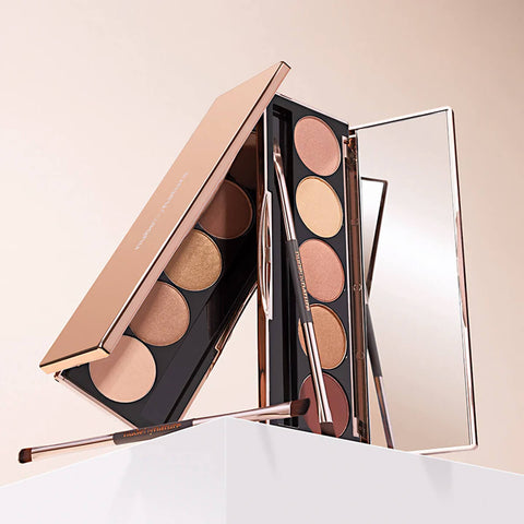 Makeup palette with brushes and mirror on a light background.